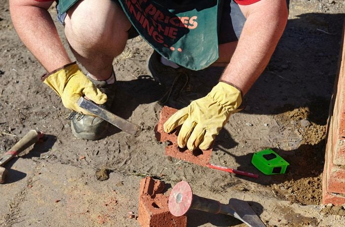 Person laying a brick.