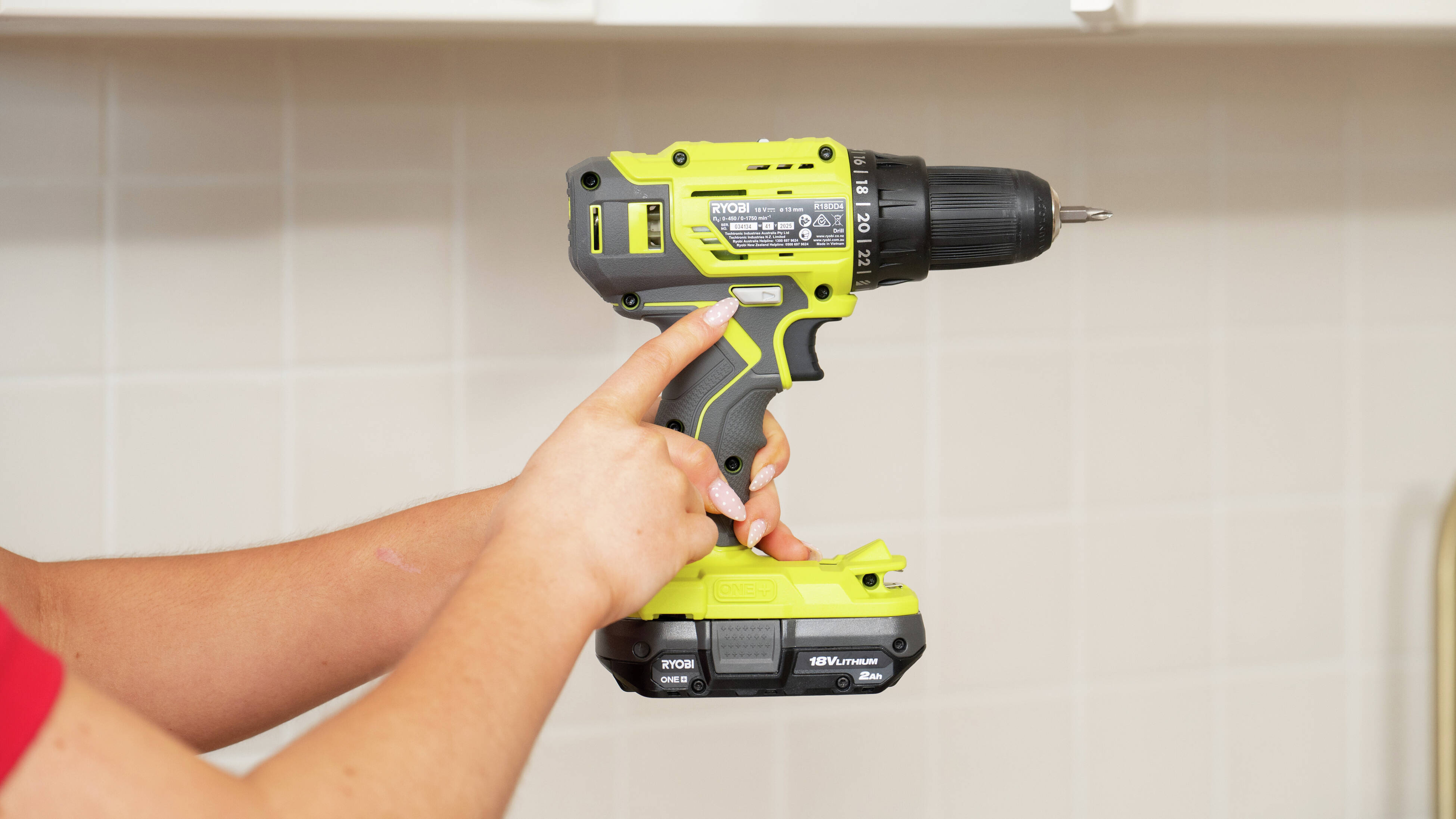 A close-up of a drill driver showing the forward/reverse switch and variable speed trigger for better drilling control.