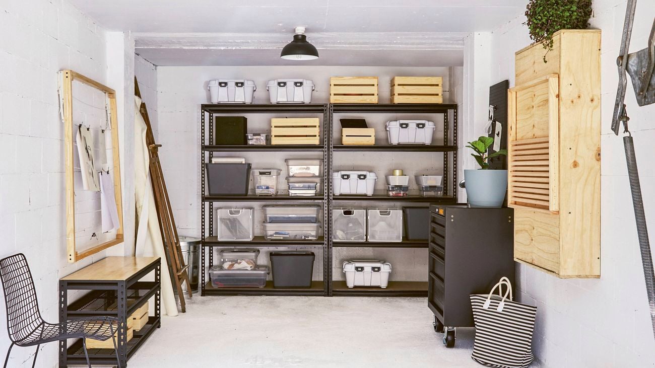 A well-organised garage or storage room with metal shelving units, various storage containers and a workbench.