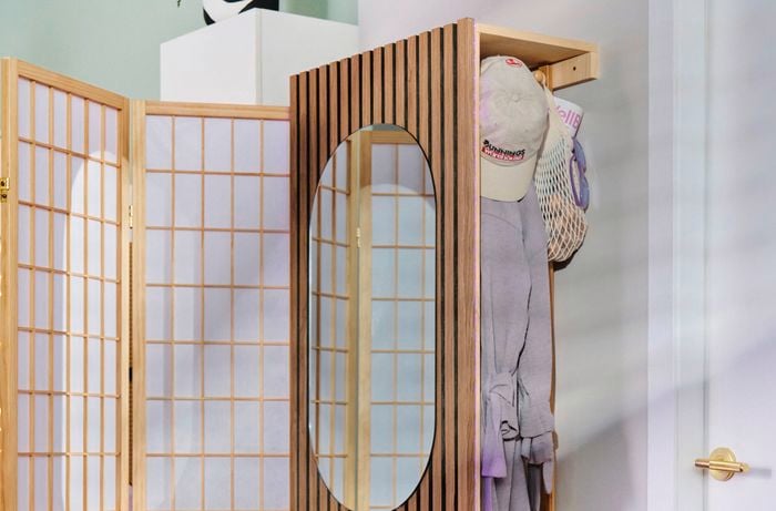 Close up of an entryway cloak room, with timber cladding and a divider