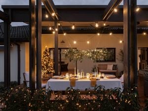A Christmas chandelier above a table setting