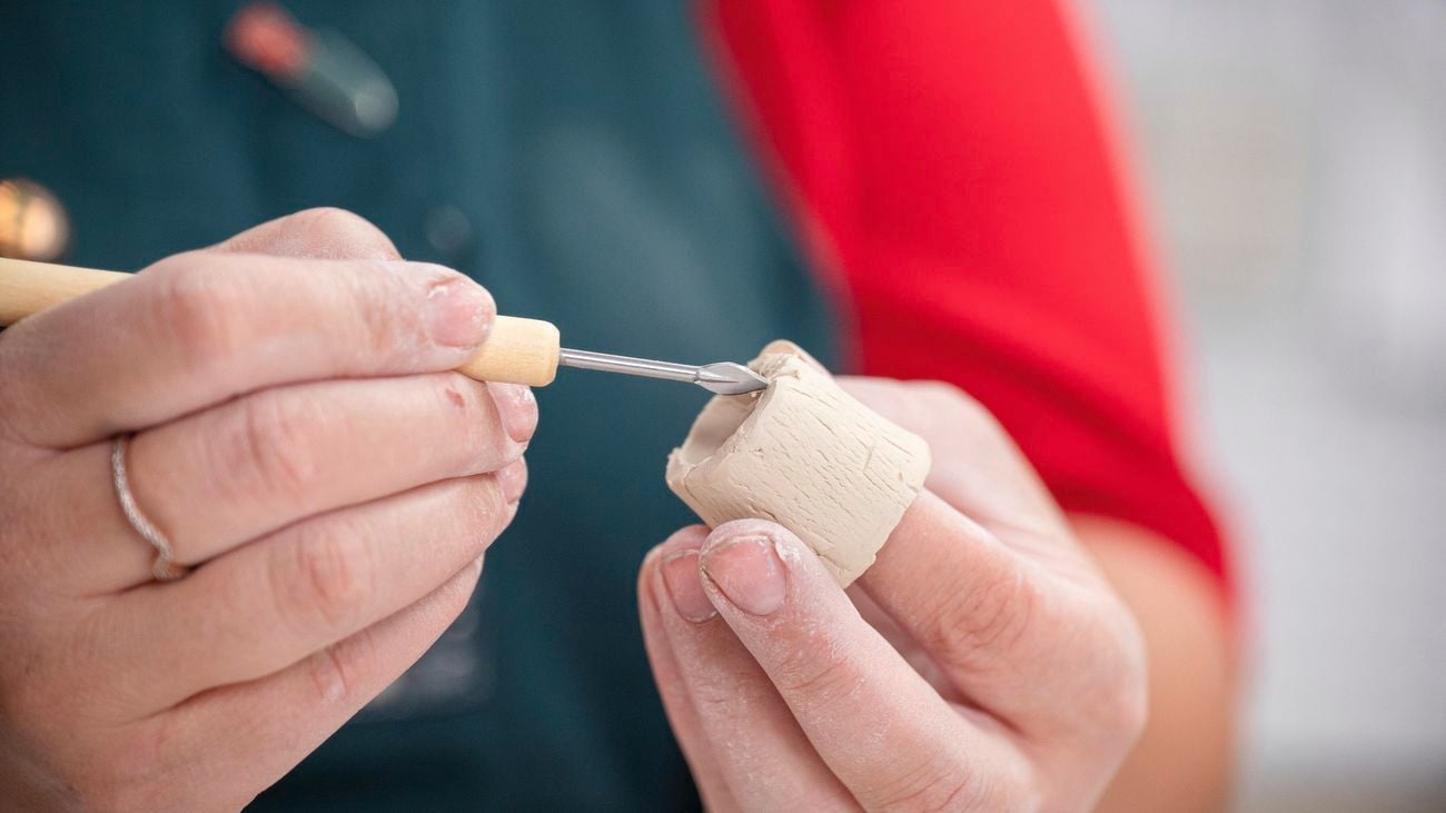 A bunnings team member scoring and placing a clay ring on base.