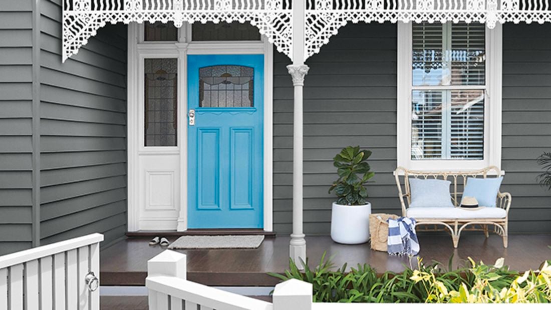 Sky blue front door in a modern grey weatherboard villa.