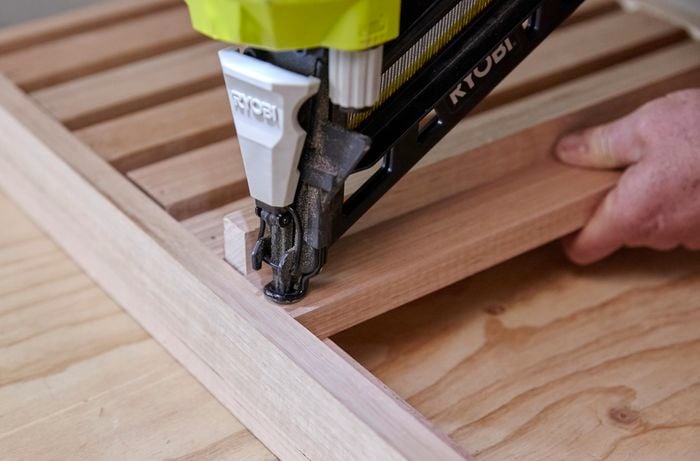 Person nailing slats to table frame