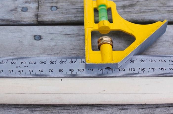 A square rule used to mark a piece of dowel for drilling dowel holes