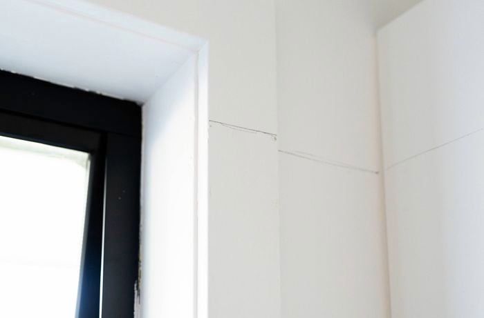 A straight pencil line drawn along the wall corner and window frame to mark the level for a colour capping paint design.