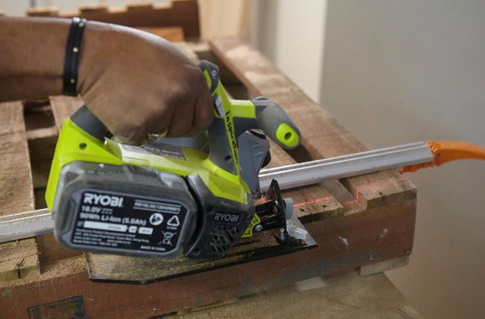 Person cutting timber slats with circular saw