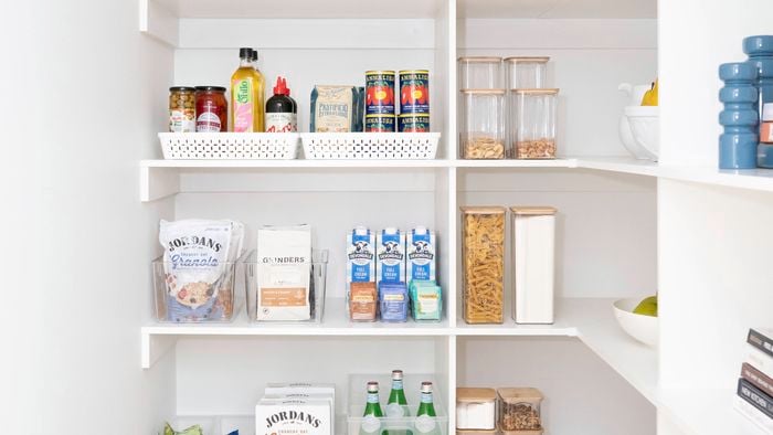 Kitchen pantry with white shelving, neatly displayed with white storage containers