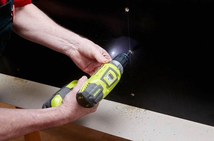 Person drilling holes in timber