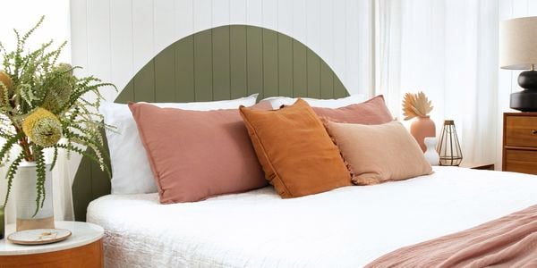 Bedroom with green wall panelling, double bed and bedside tables.