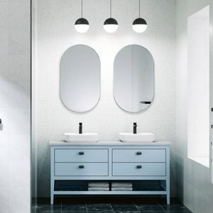 A bathroom with 2 mirrors on the wall, 2 basins on a cupboard and a shower