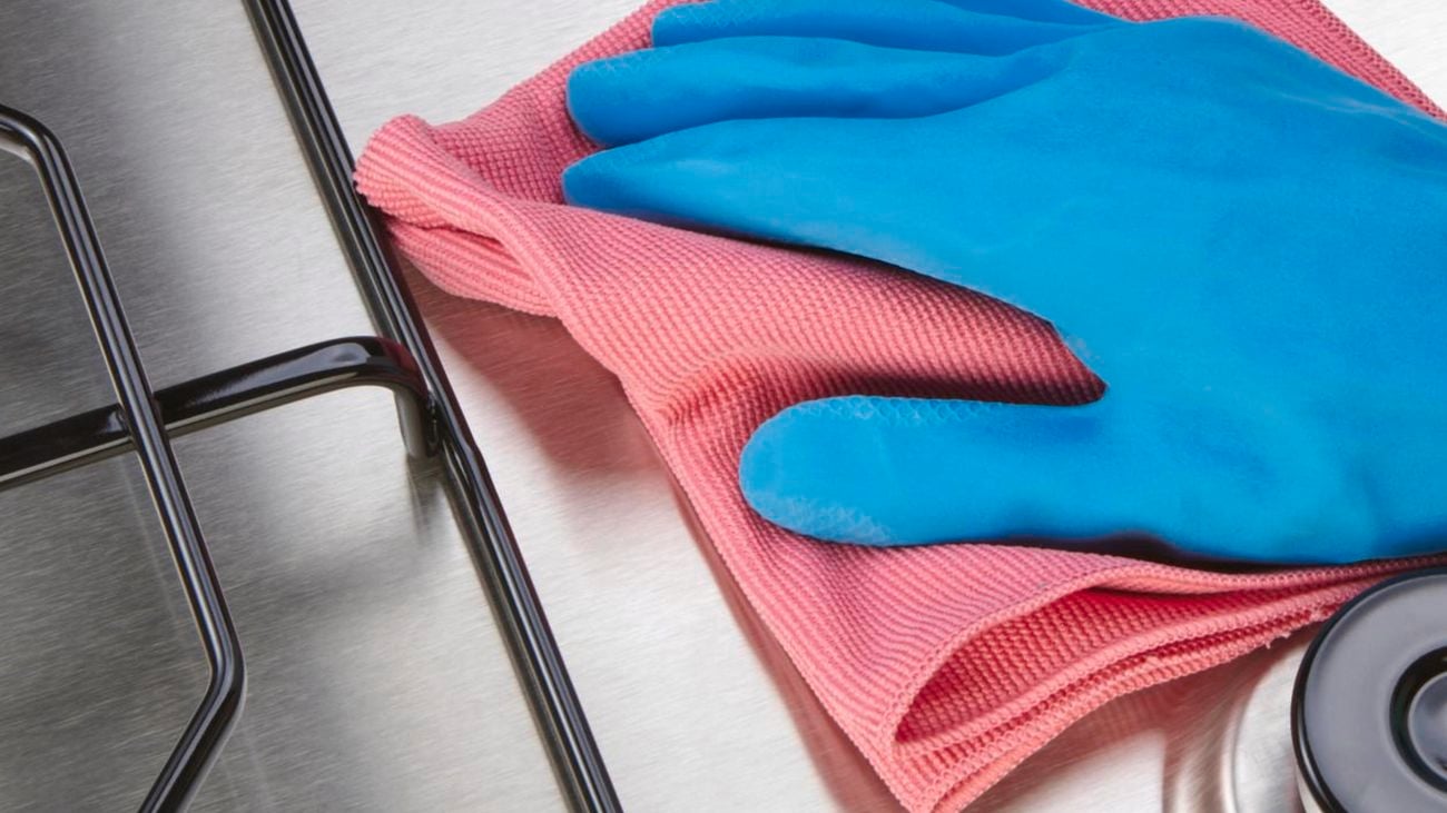 Person polishing stovetop with cloth.