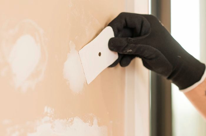 Applying plaster filler into small holes. 