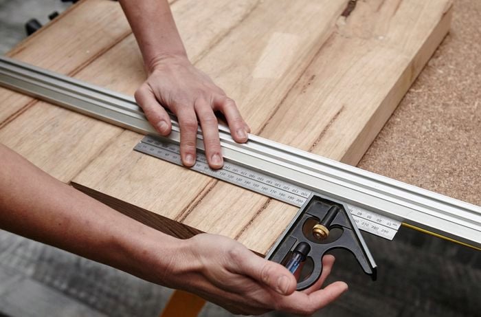 A square rule being used to measure the coat rack base for cutting