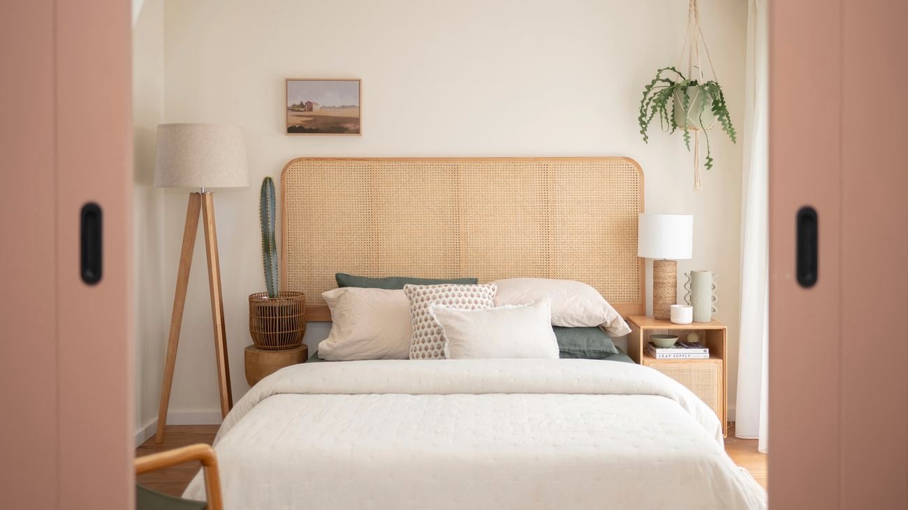 In a neatly decorated room, there are five basketballs hanging on the wall. A guitar is placed in the corner, alongside a study desk and chair. Additionally, there is a small bed with a brown beanbag