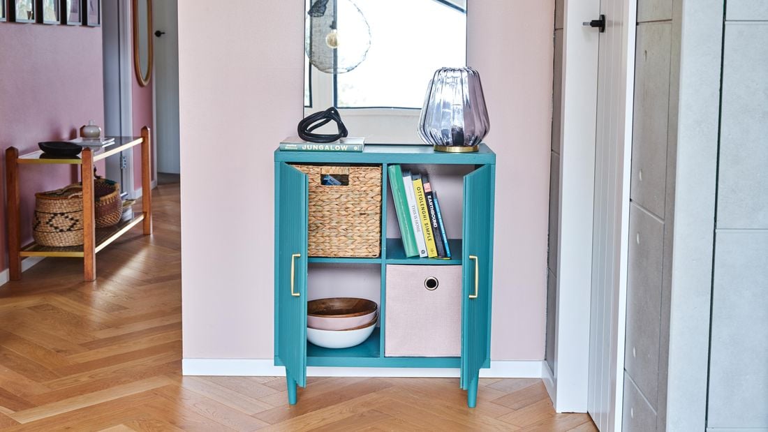 green cabinet sitting on timber floors, pink walls