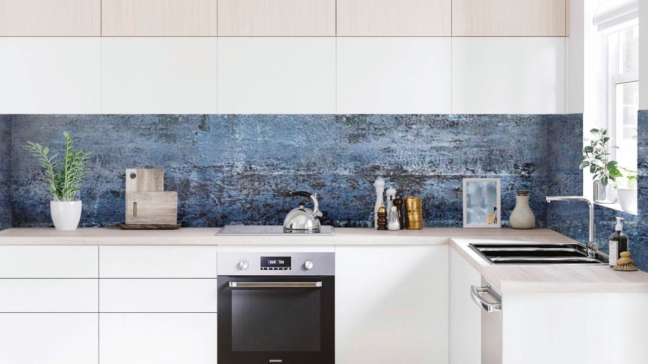 Modern white kitchen with a built-in oven and dishwasher, styled with a textured blue-look splashback, benchtop appliances and decorative accessories.