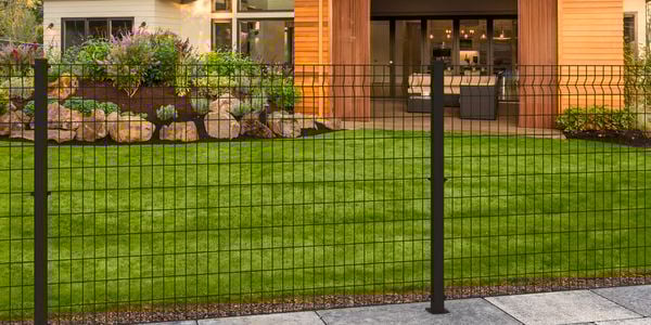 Black wire grid fence at the front of a house