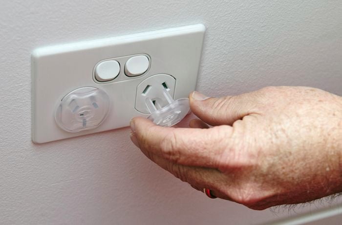 A person inserting a power point protector into a power point