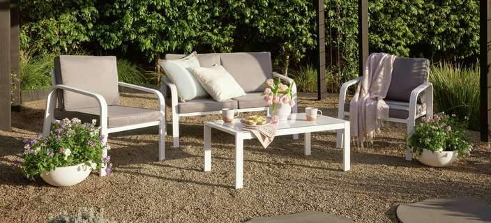 Outdoor sofa & coffee table under a pergola in a backyard
