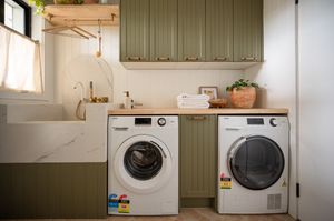 A modern laundry room featuring a front-loading washing machine and a matching dryer placed side-by-side.