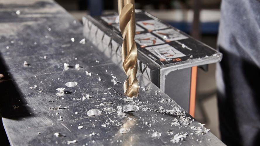 Drilling holes into metal with drill machine.