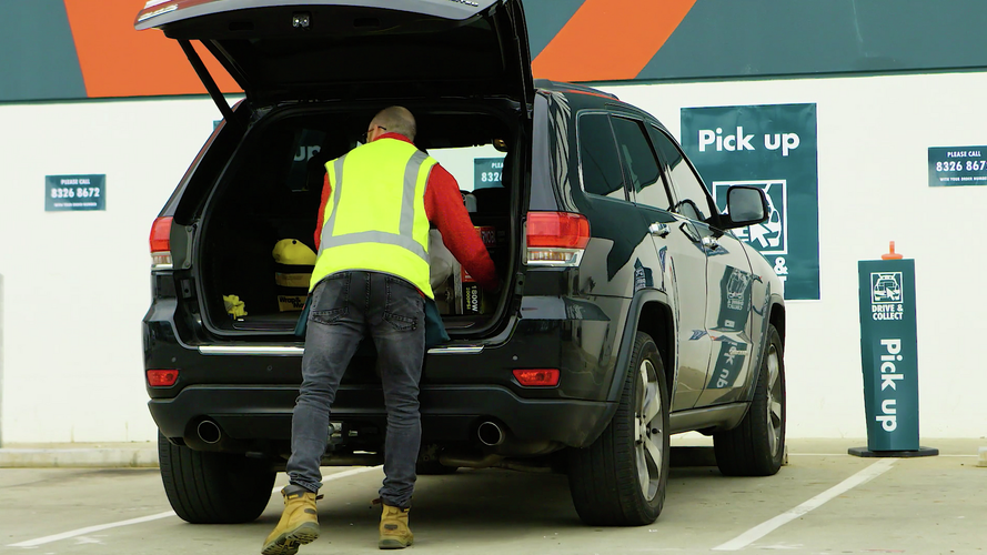 Bunnings Team Member placing goods into car.