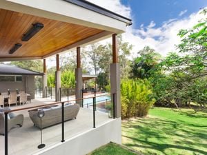 Outdoor lounge area with a black, Heatstrip heater attached to the ceiling.