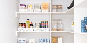 Kitchen pantry with white shelving, neatly displayed with white storage containers