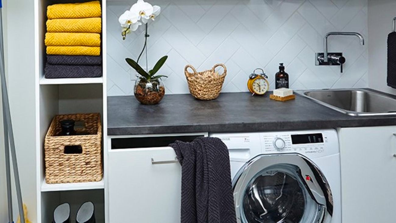 Laundry with under-bench washing machine and vertical storage with towels