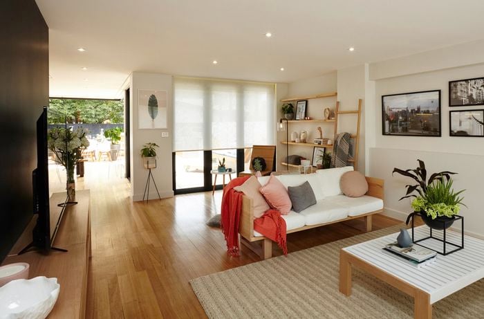 An open plan living room with television, lounge and coffee table