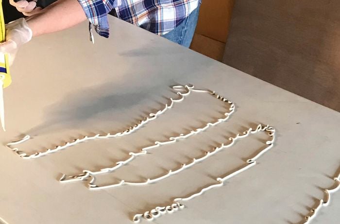 Construction adhesive applied to a plywood board