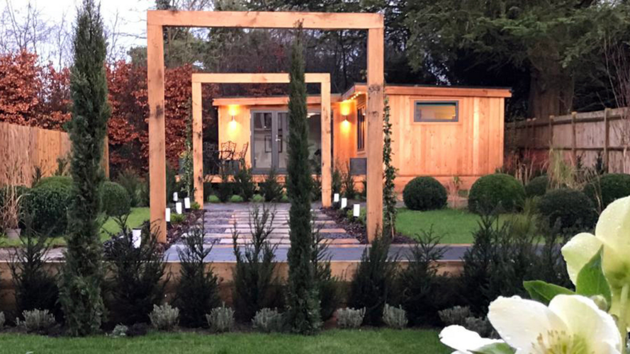timber house with green garden and outdoor lighting