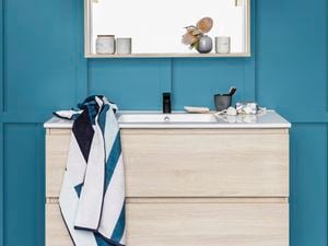 Bathroom vanity with blue and white striped towel. 