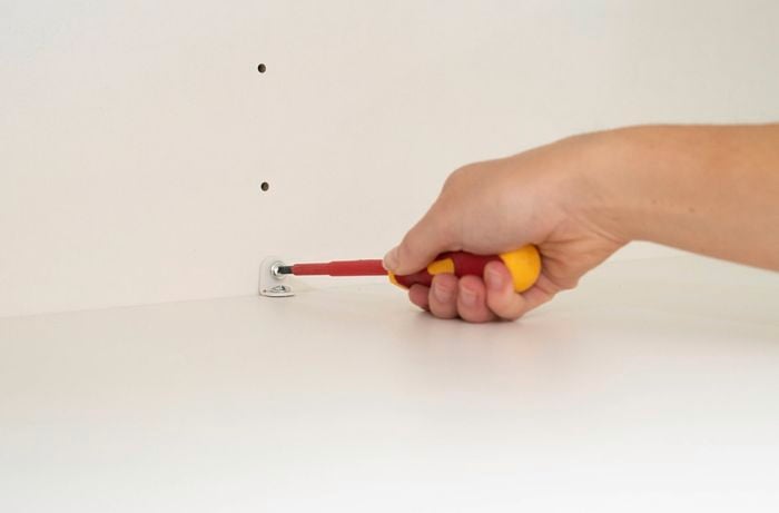 Install anti-tip bracket inside a cabinet