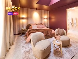 : Bright bedroom with curved headboard, warm lighting, and red accents.