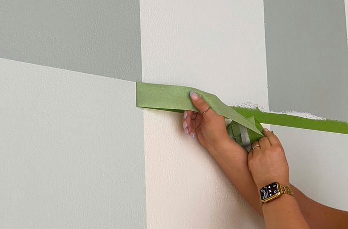 Person removing tape to show blue and white, gingham checks.
