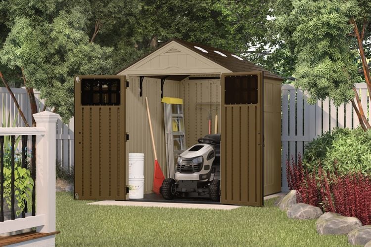 Backyard garden shed containing a ride-on mower, ladder and garden tools