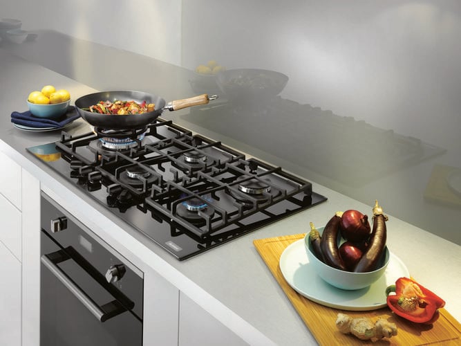 Person cooking stir fry on a gas cooktop