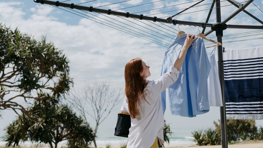 Woman hanging washing on a Hills Rotary Clothesline.