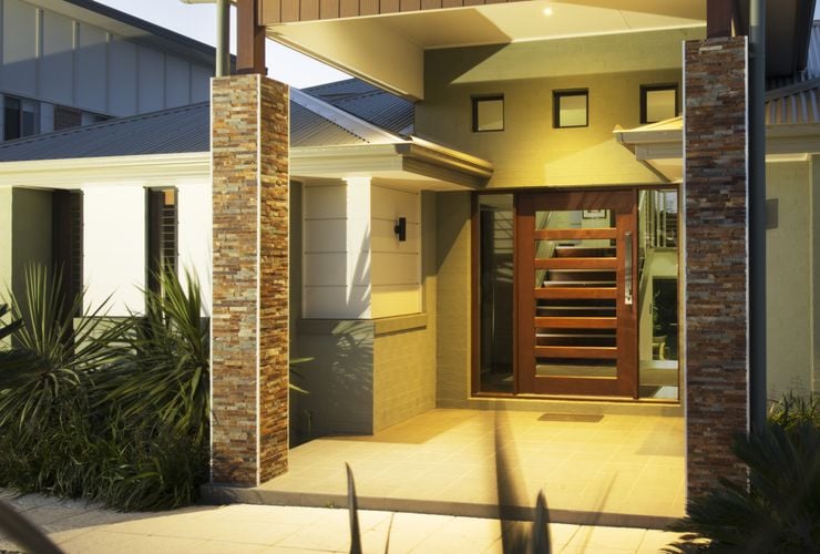A covered entryway with large timber and glass front door