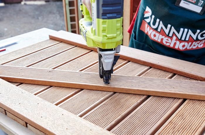Person using a fixing gun on timber to create a crossbrace.