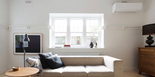 Styled living room featuring an air conditioner, beige sofa, timber coffee table and console