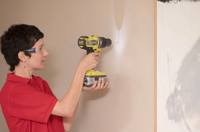 Drilling holes in the wall.