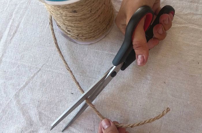 person trimming a spiral of jute