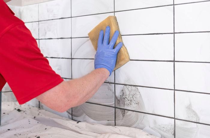 Wipe away grout residue using a sponge