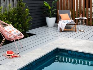 Pool with pale coloured decking and outdoor furniture