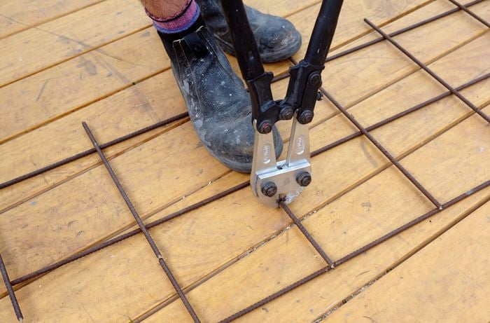 Boltcutters being used to trim a wire mesh length to size
