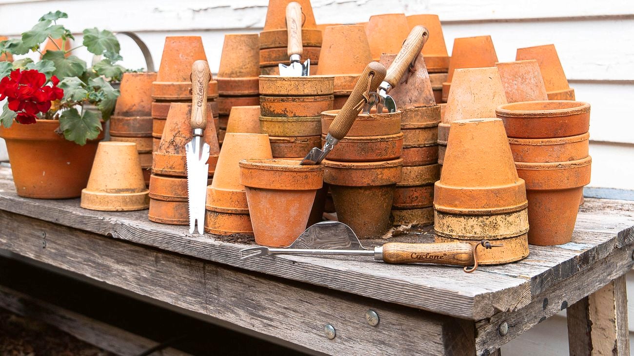Brown clay pots stacked on a wooden table outside