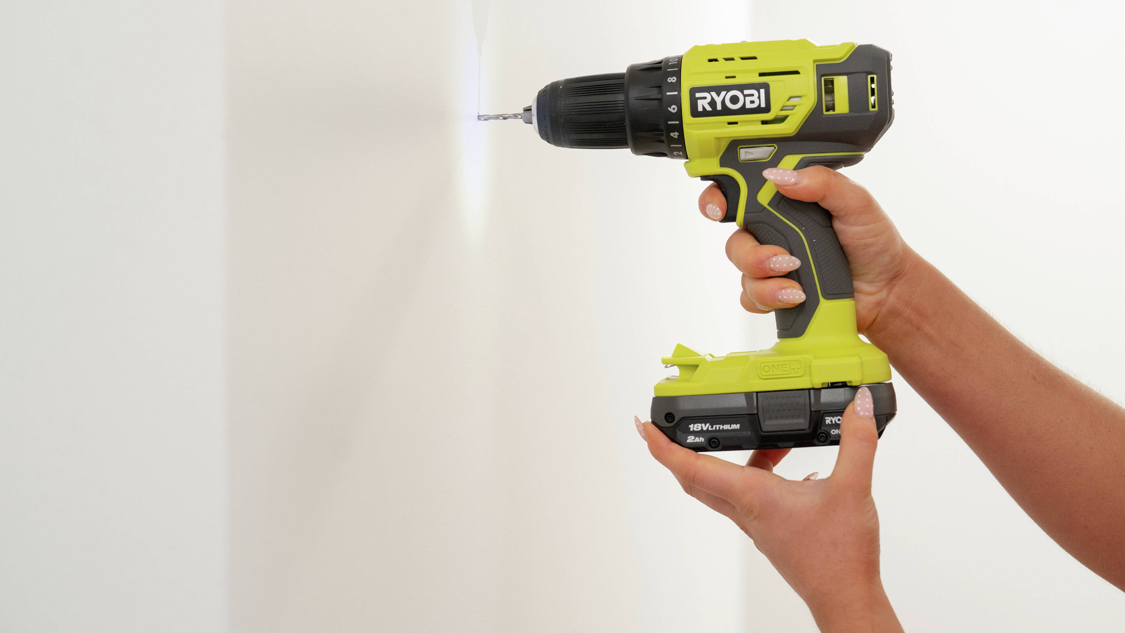 A person is using a drill driver to create a pilot hole before installing a screw during a D.I.Y. project. 
